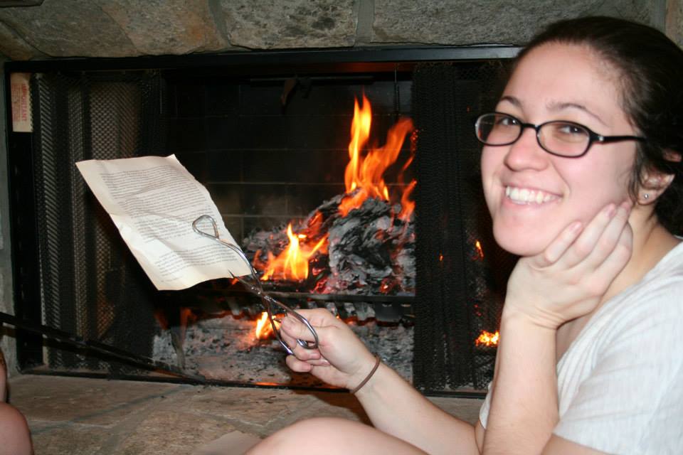 A photo of a woman burning pages of the book The War Against Boys by Christina Hoff-Sommers.