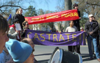 Student protesters hold banners that read "CASTRATE" and "give them equal measure."