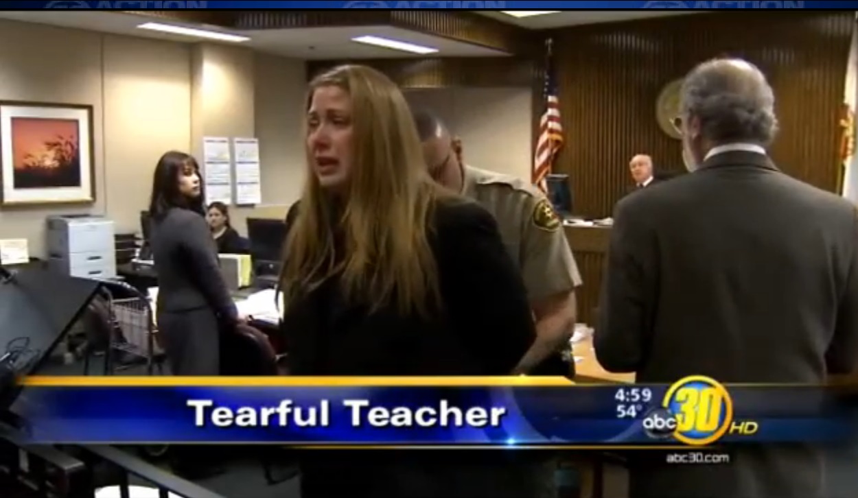 A still image of Megan Denman in tears as she is led away by an officer after being sentenced for statutory rape.