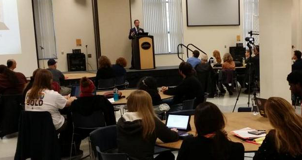 A still photo of Jonathan Taylor presenting as the keynote speaker at the Male Students in Peril conference at Kennesaw State University.