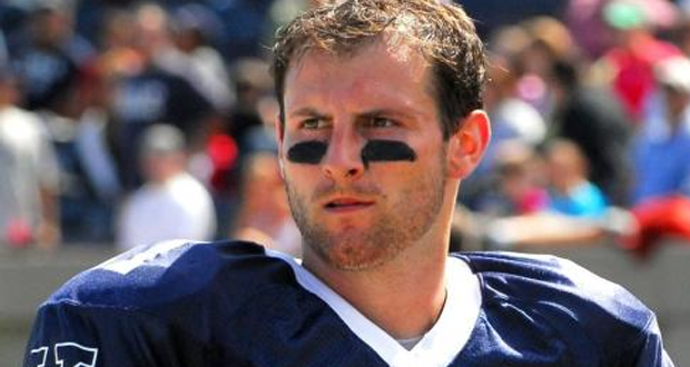 A photo of Patrick Witt in full football gear (except his helmet). He is gazing off into the distance, appearing focused but concerned.